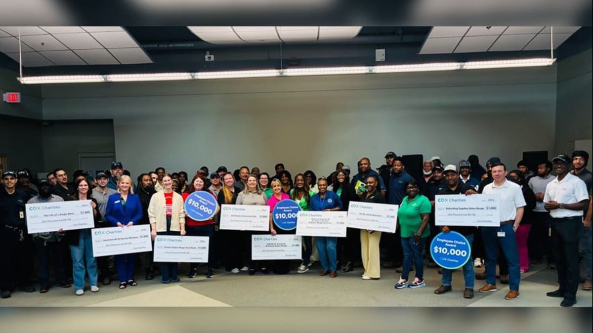 Cox Charities representatives presenting oversized check to smiling nonprofit leaders in Baton Rouge office
