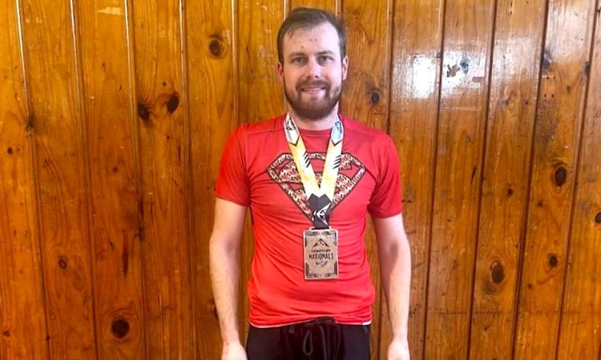 Ryan in Brazilian Jiu-Jitsu gi uniform celebrating his medal win at national competition