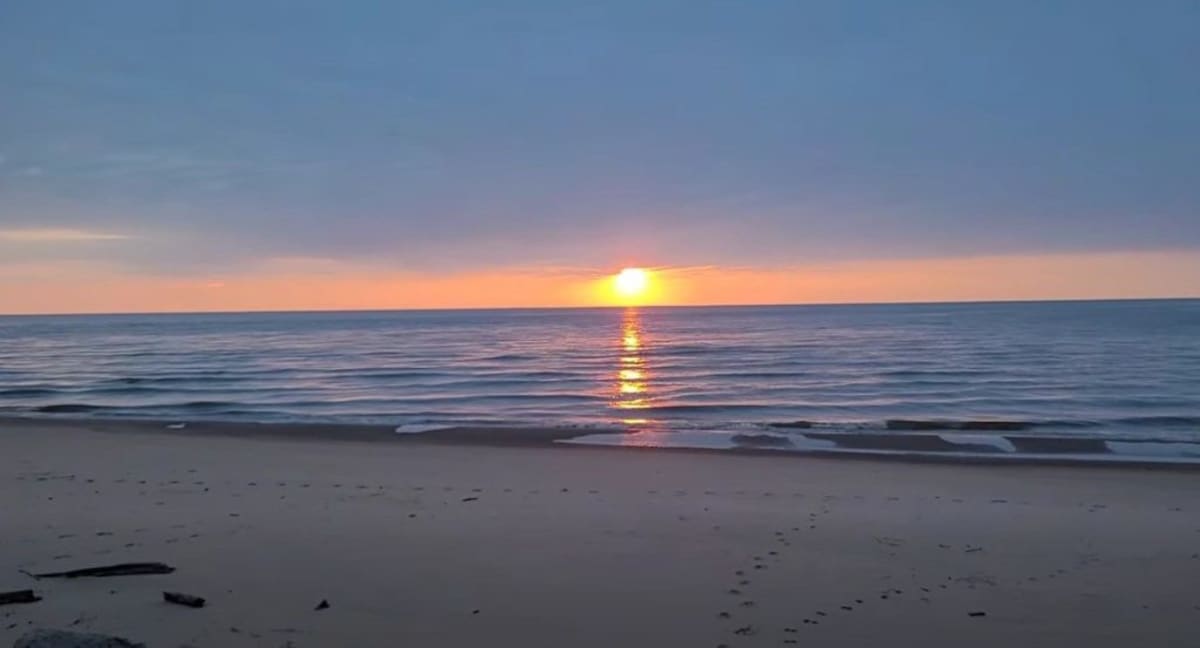 Volunteers collecting plastic waste and debris along a Lake Michigan beach shoreline