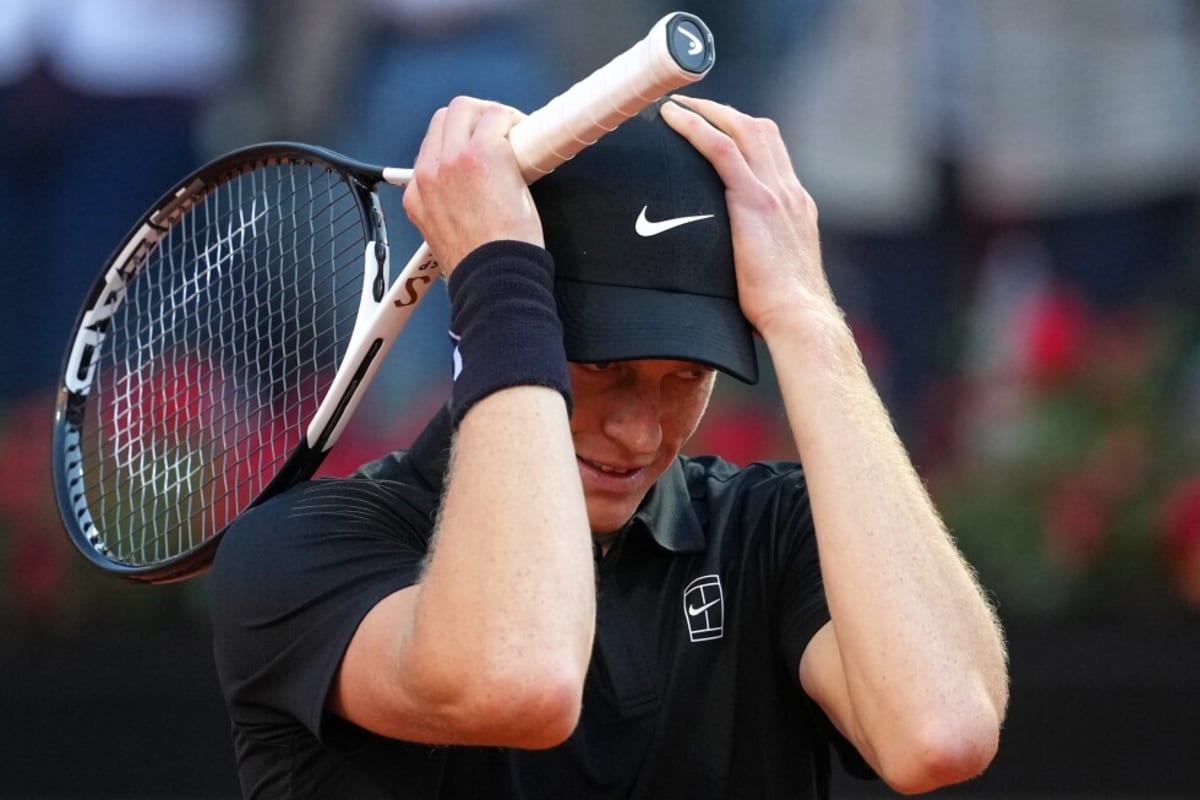 Jannik Sinner holding trophy overhead celebrating Italian Open victory in Rome with crowd cheering