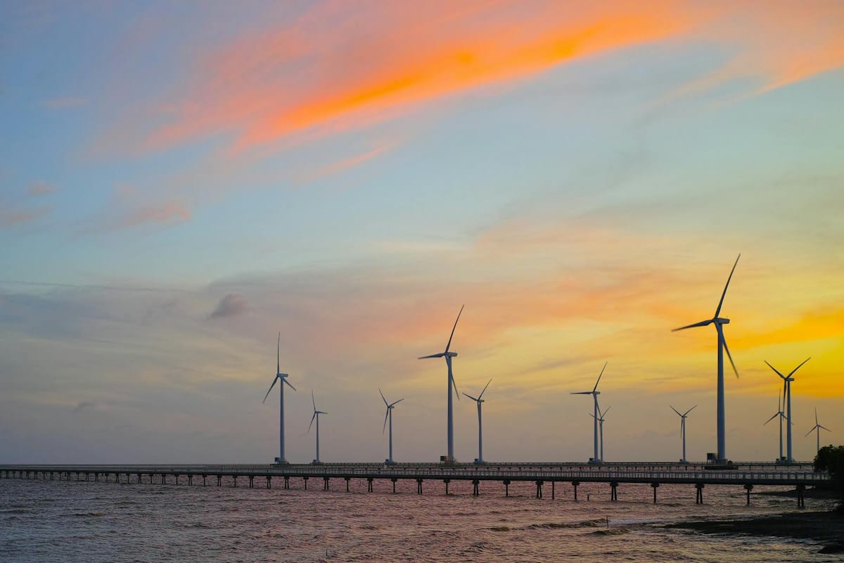 Offshore wind turbines generating clean electricity in coastal Southeast Asian waters at sunrise
