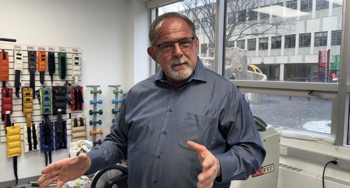 Dr. Rob Agostinis smiling in medical attire after recovering from rare paralytic autoimmune disease