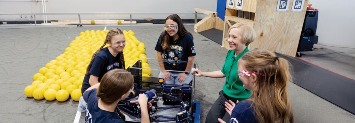 Students working with robotics and 3D printers in modern STEM lab facility Michigan