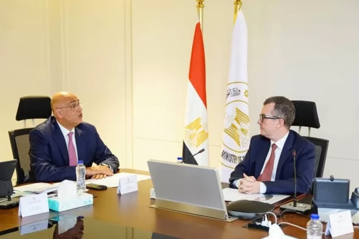 Egyptian entrepreneurs collaborate in modern startup workspace with laptops and planning materials