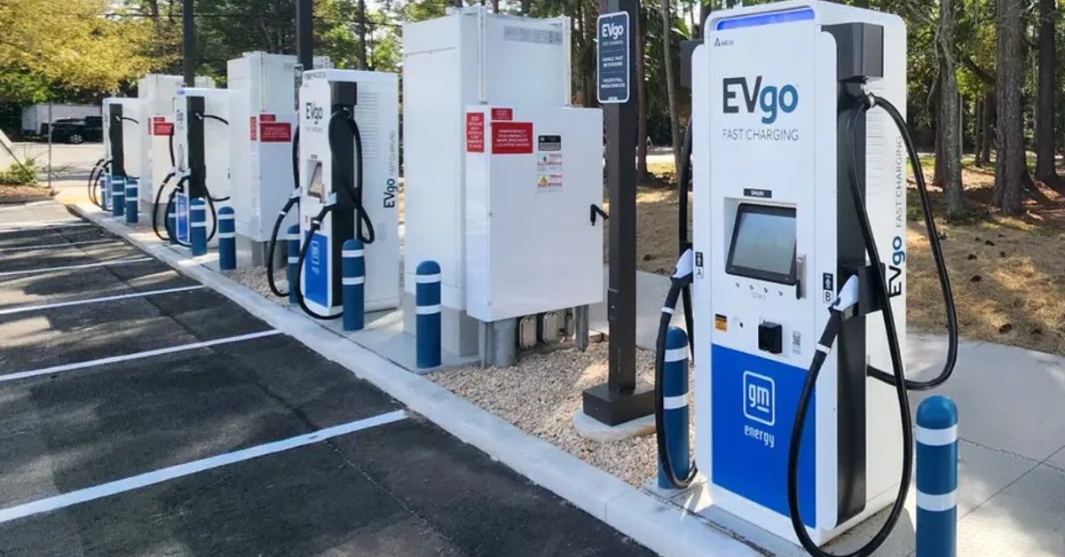 Electric vehicle plugged into EVgo fast charging station at suburban shopping center parking lot