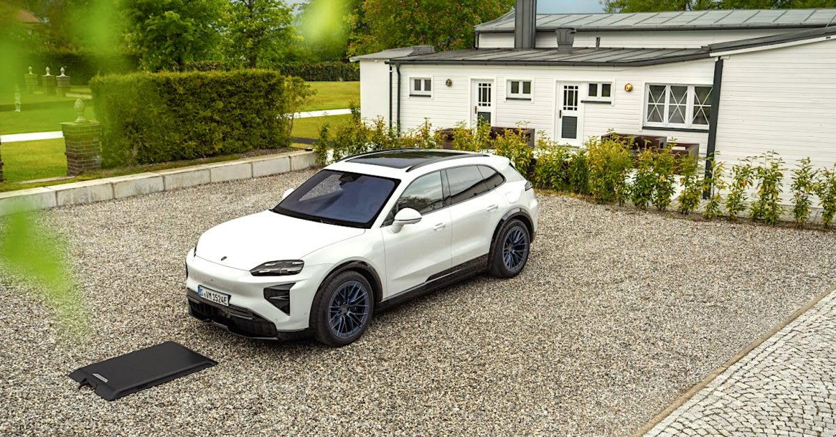 Black Porsche Cayenne Electric SUV parked over wireless charging pad in modern garage