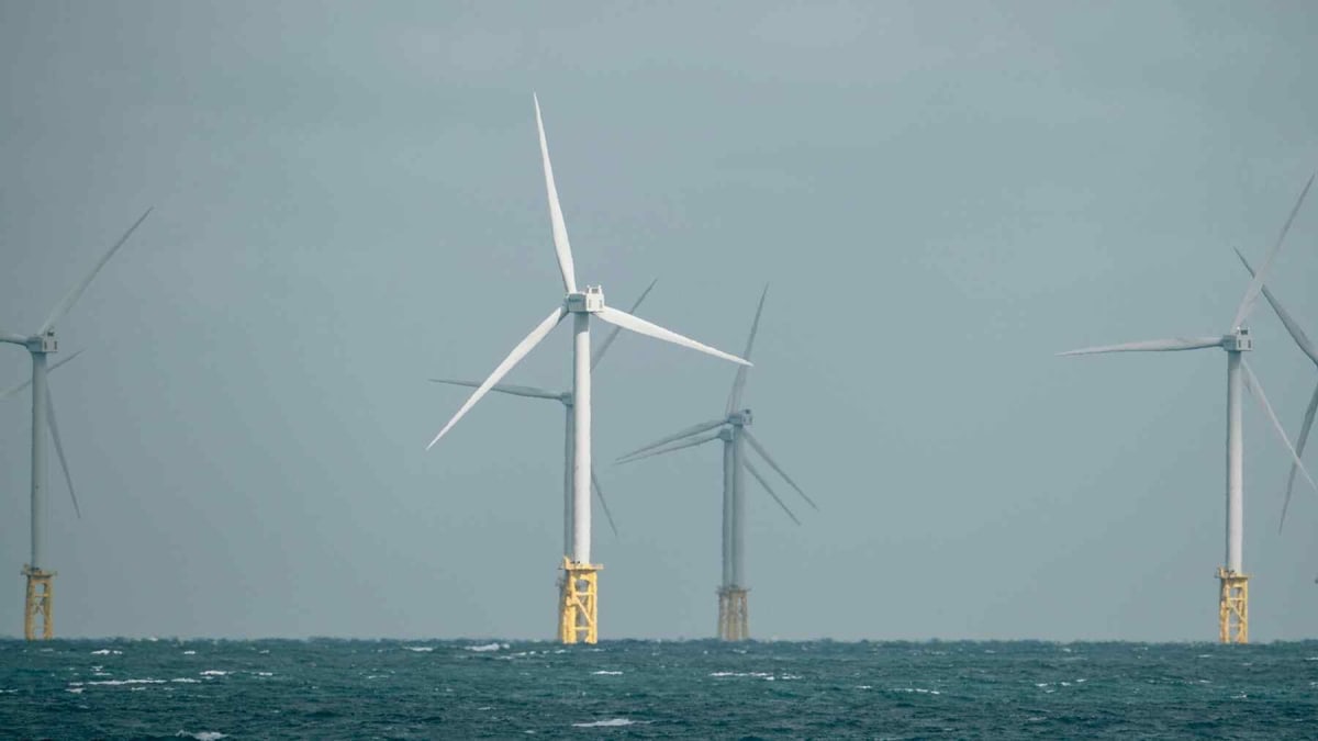 Offshore wind turbines spinning in ocean waters generating renewable electricity for technology manufacturing