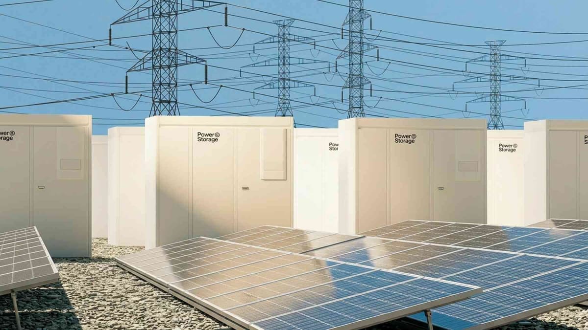 Modern battery storage facility next to wind turbines in Swedish countryside landscape