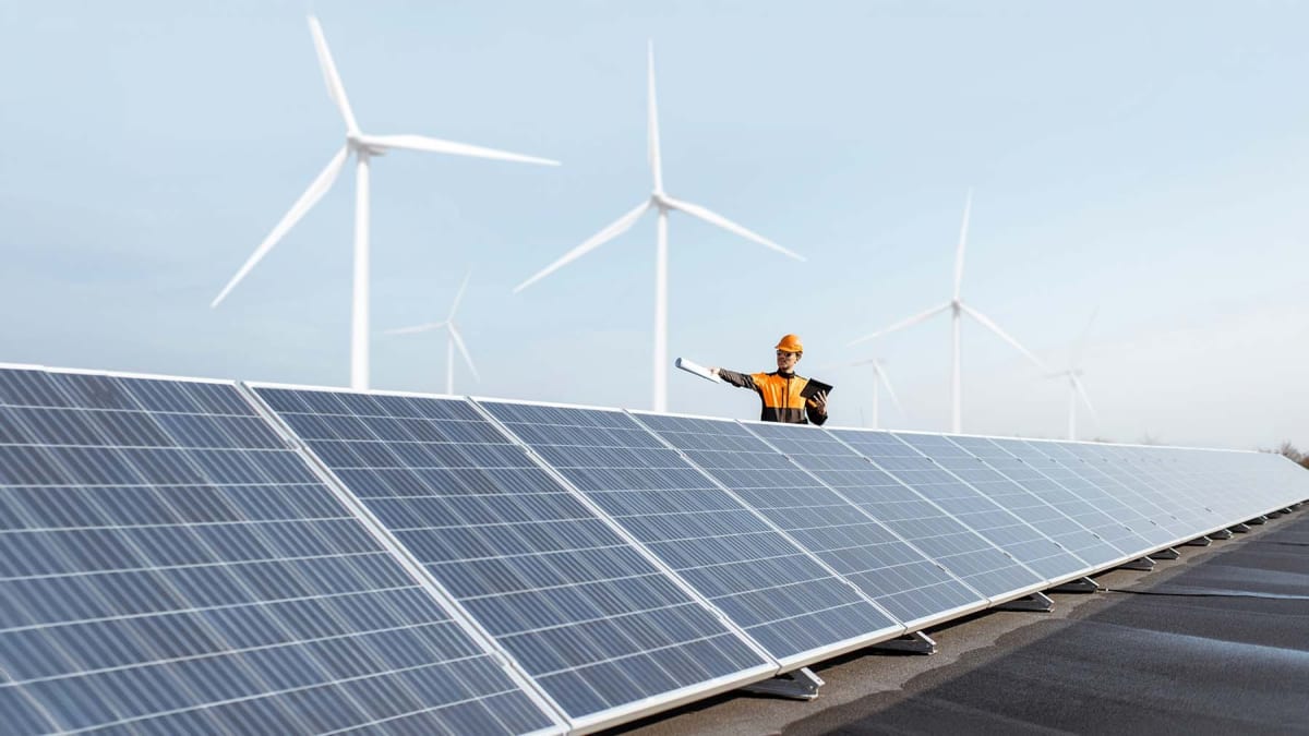 Modern wind turbines standing beside large battery storage facility in German countryside