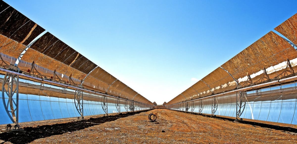 Solar panels stretching across New Mexico desert landscape under bright blue sky