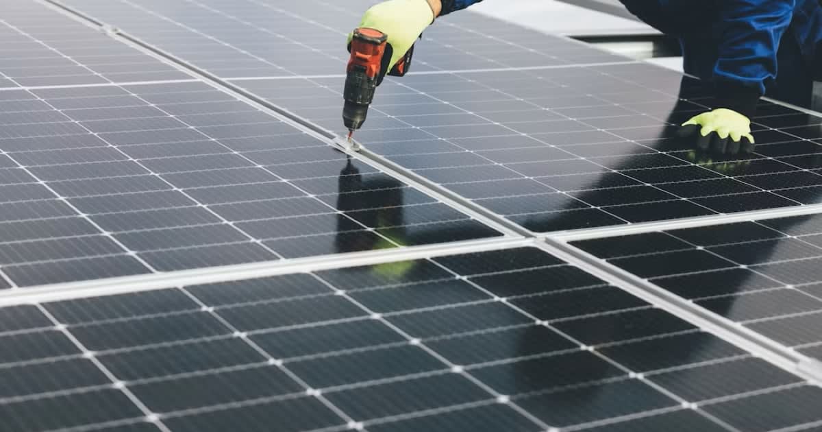 Solar panels installed on residential rooftops across British neighborhood under sunny sky