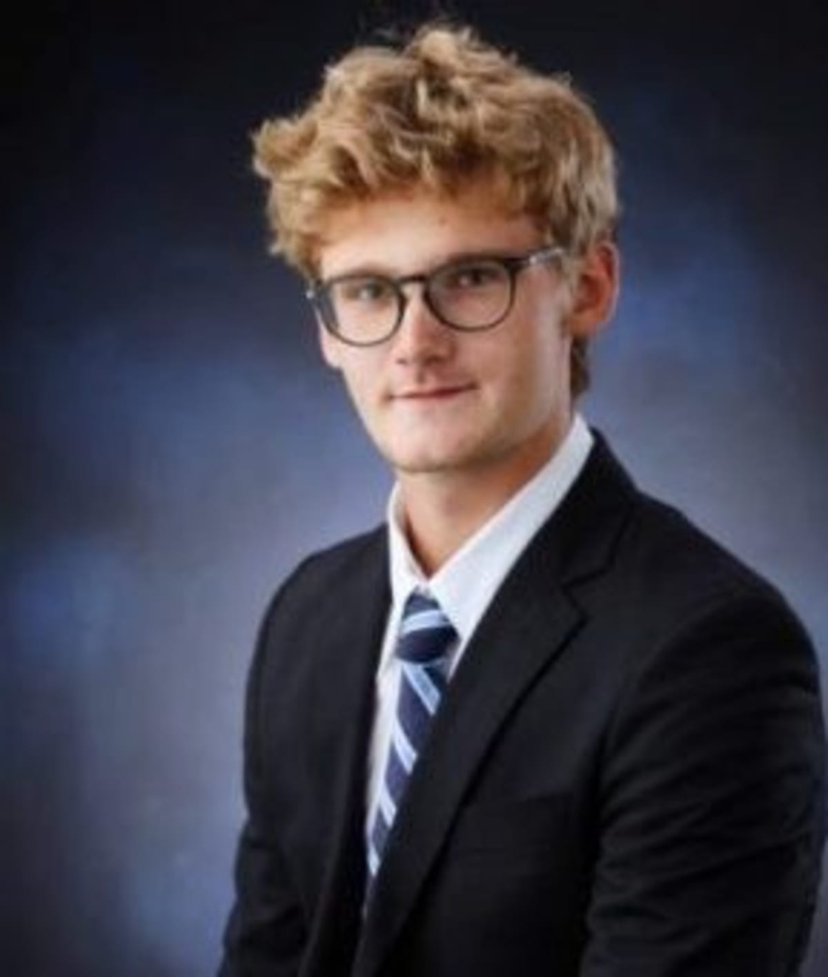 High school student Bleu Strnad standing near metal donation boxes in a parking lot