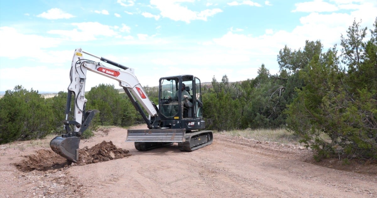 Volunteer operating grading equipment on damaged gravel driveway in Beulah Colorado