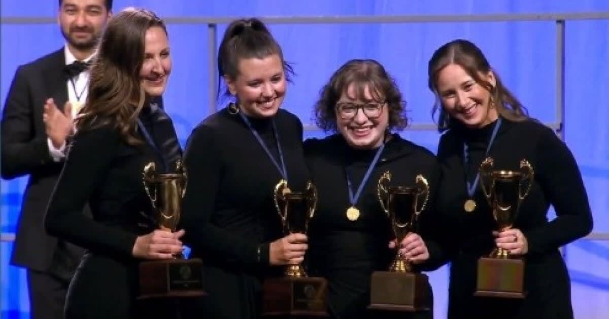 Four women from barbershop quartet GQ celebrating their historic championship victory together