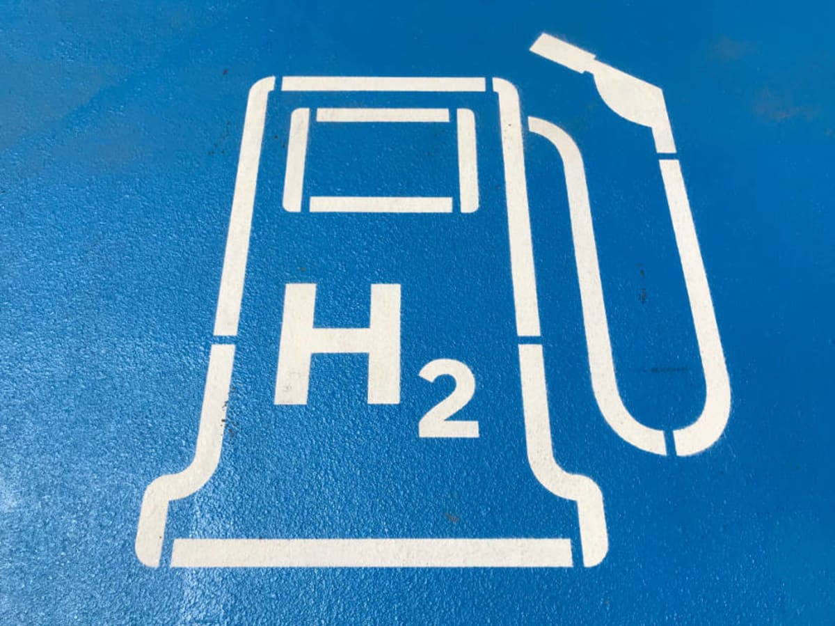 Scientists examining hydrogen fuel cell technology in university laboratory research setting