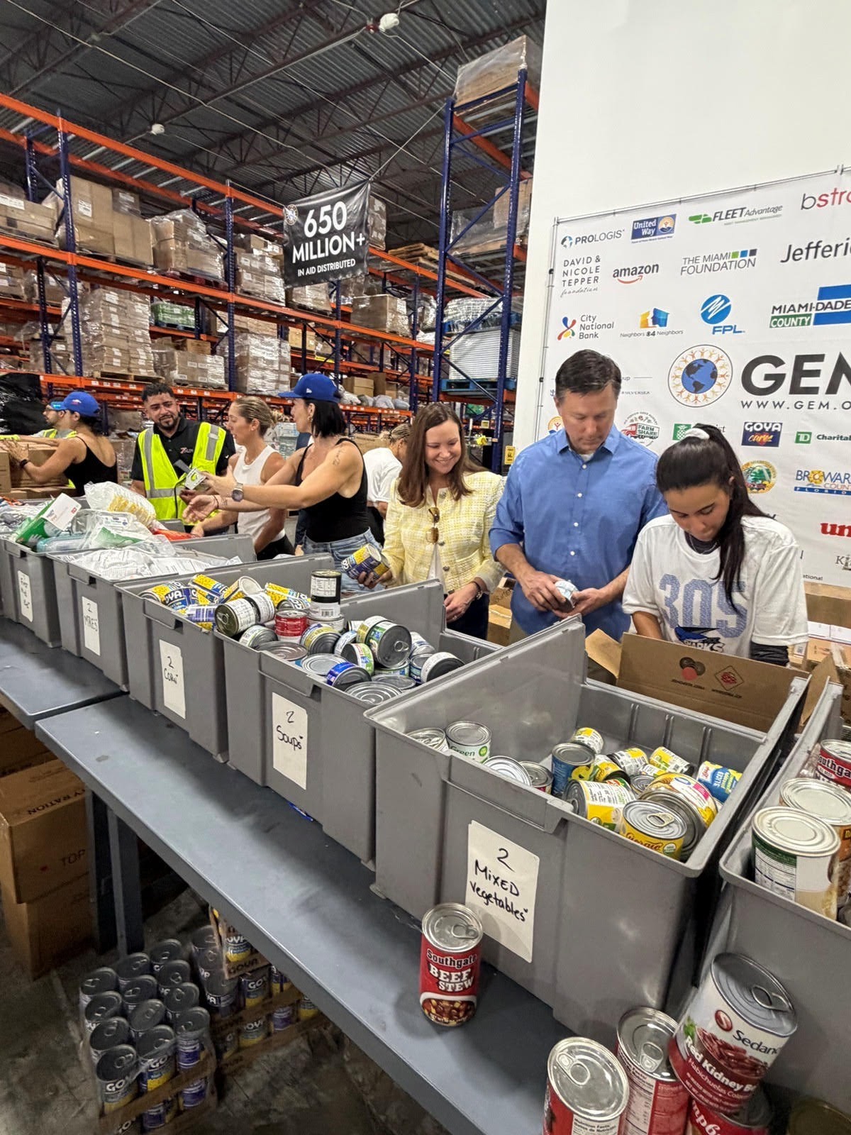Volunteers packing emergency relief boxes and food supplies at Global Empowerment Mission warehouse in Doral Florida