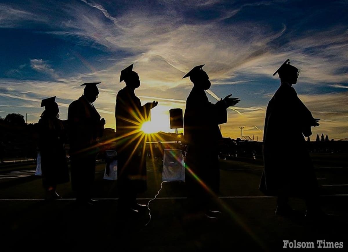 Group of diverse students celebrating with graduation caps and scholarship award certificates