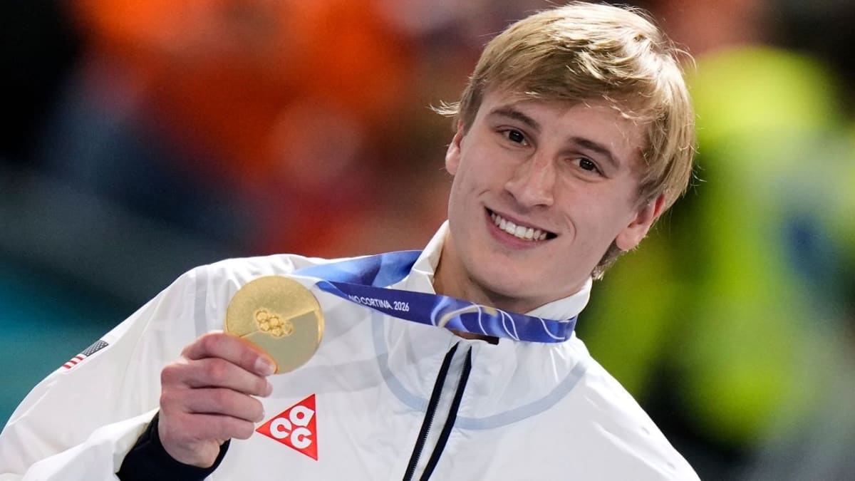 Jordan Stolz celebrating with gold medal on podium at 2026 Winter Olympics speedskating event