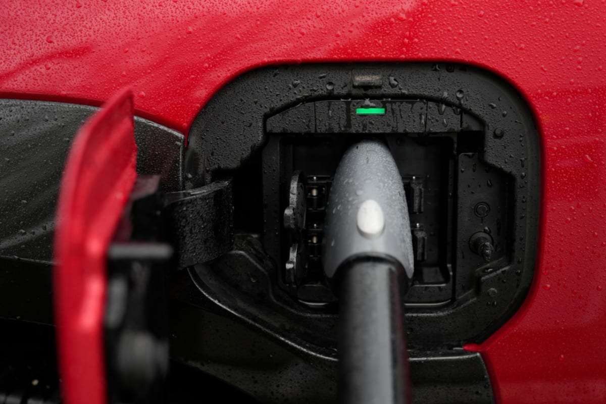 Electric vehicle charging at home station in Kentucky driveway at night