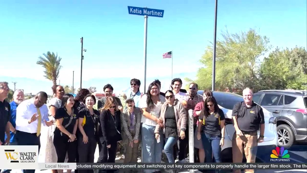 Two high school students standing near temporary street signs bearing their names in Desert Hot Springs