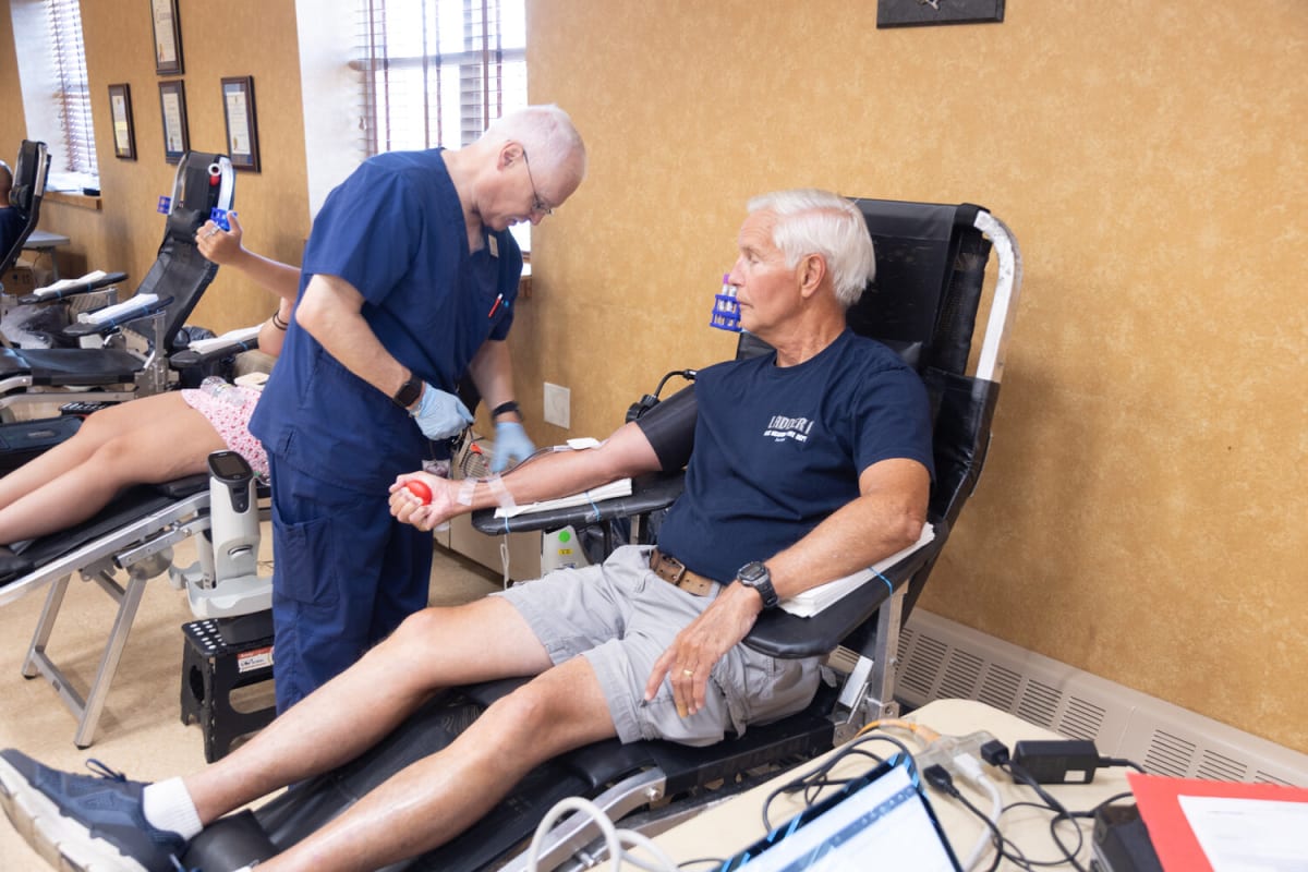 ** Firefighter donating blood at East Meadow Fire Department community blood drive honoring nurse Carol Gyss-Gravely