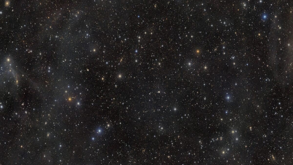 Detailed telescope image showing hundreds of thousands of distant galaxies across deep space