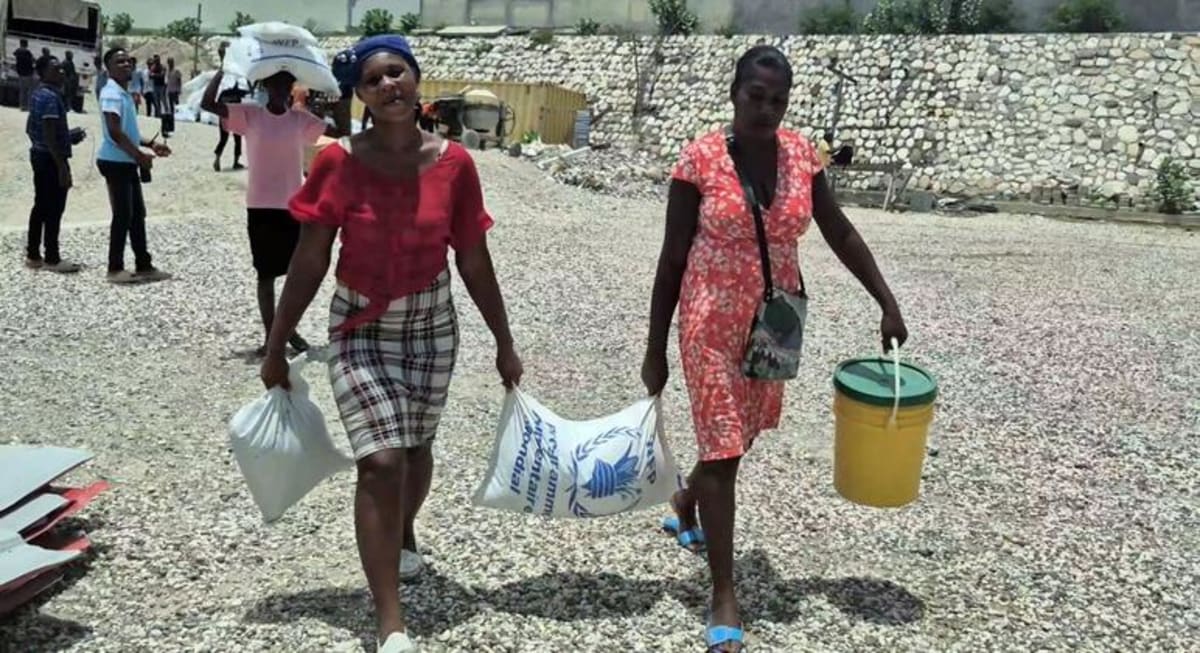 ** Women in Port-au-Prince, Haiti carrying relief aid after fleeing violence in their communities
