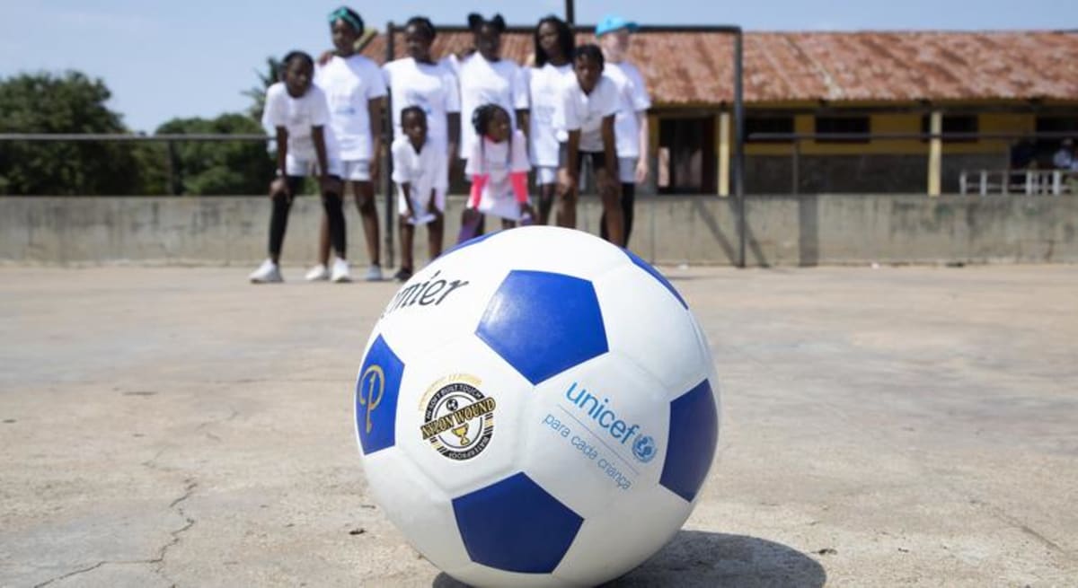 Young athletes playing soccer together at UNICEF community sports event in Mozambique