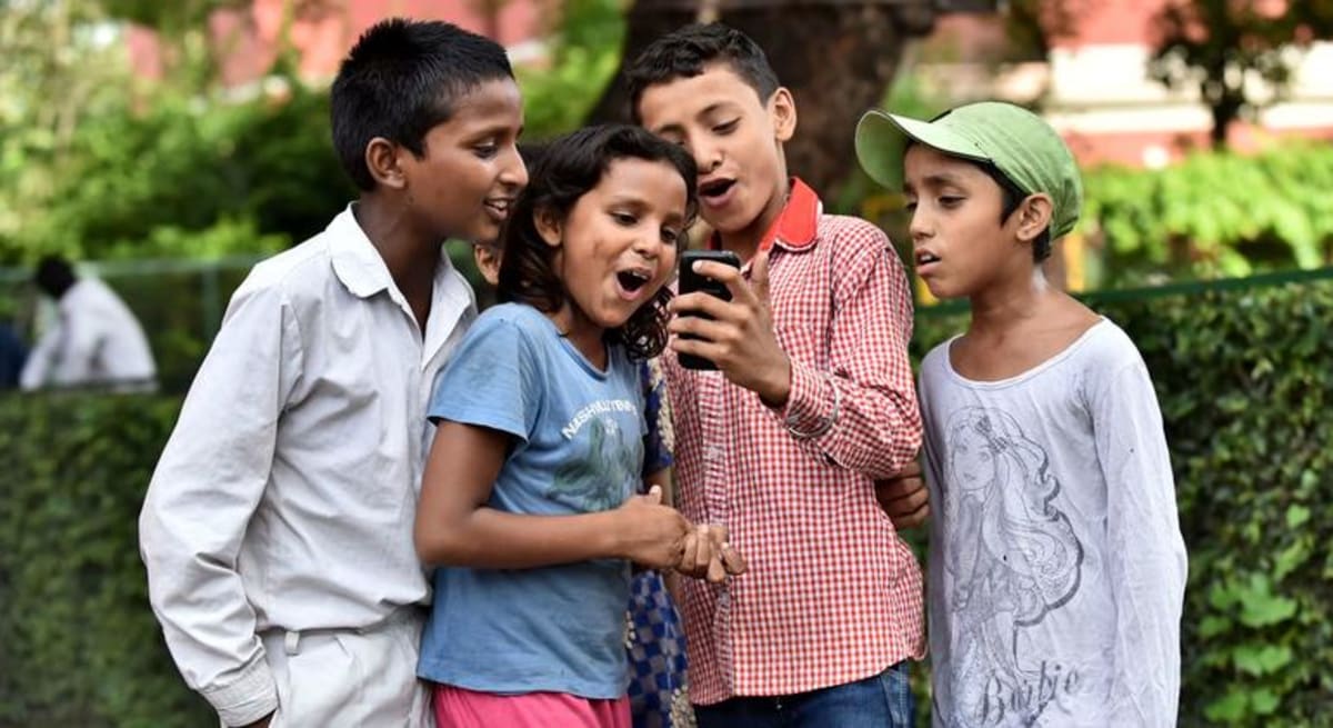 Children using digital technology with adults supporting their learning and engagement