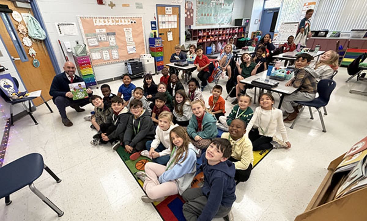Westlake Mayor JohnPaul O'Connor reading to elementary students seated on classroom floor