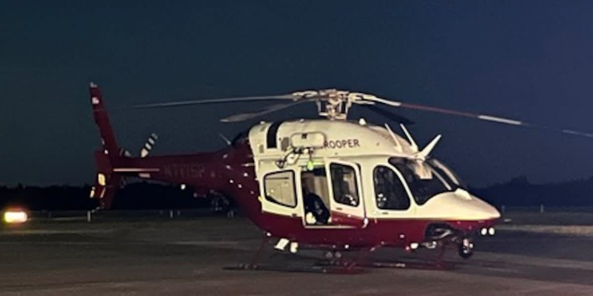Minnesota Air Rescue Team helicopter performing nighttime rescue mission over wilderness forest