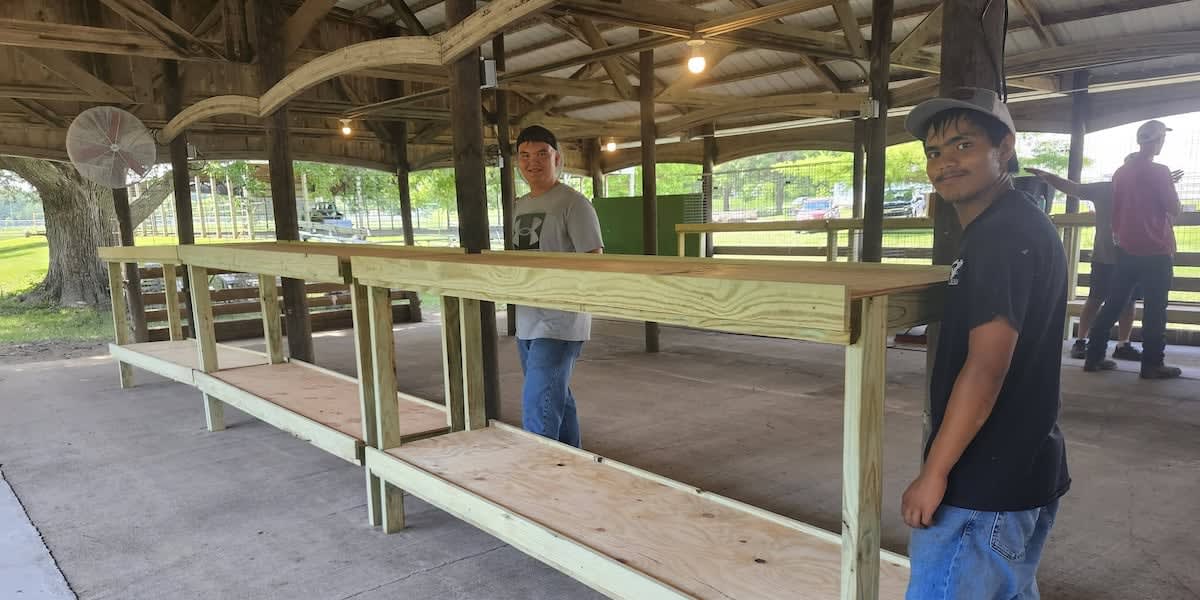 Volunteers working together to rebuild livestock pens at Story County Fairgrounds after flooding