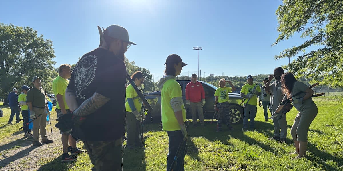 Volunteers and Kansas City council members gather along Blue River banks during World Cup cleanup event