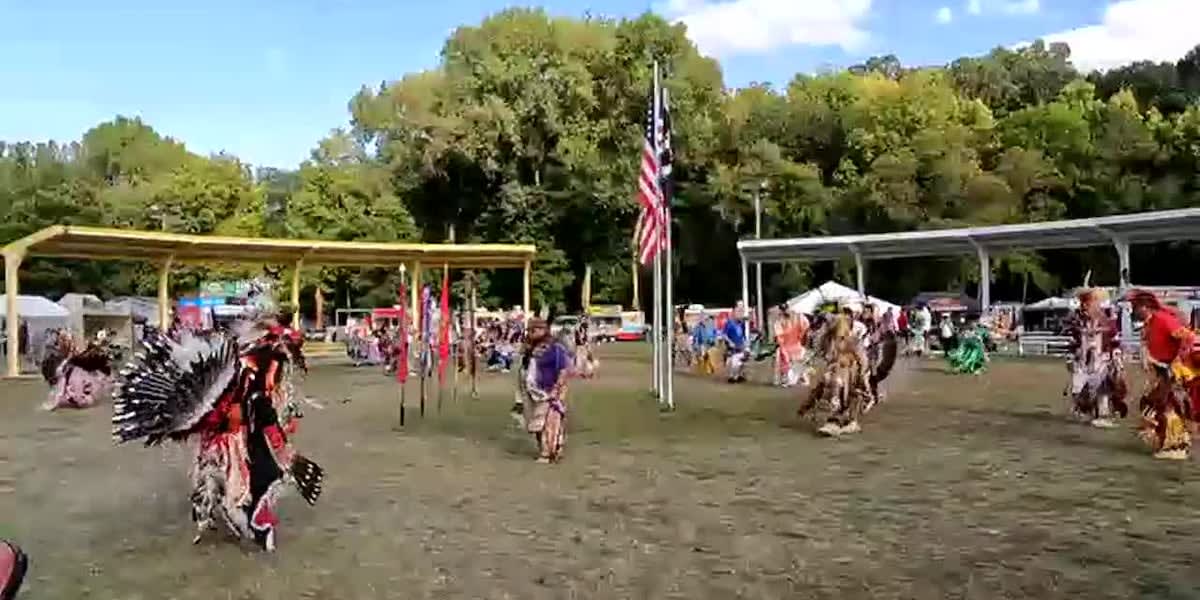 Traditional Dakota dancers in colorful regalia performing at outdoor Mahkato Wacipi pow wow celebration