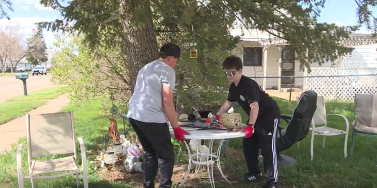 High school students helping elderly homeowner rake leaves and clear yard debris in Hebron, North Dakota