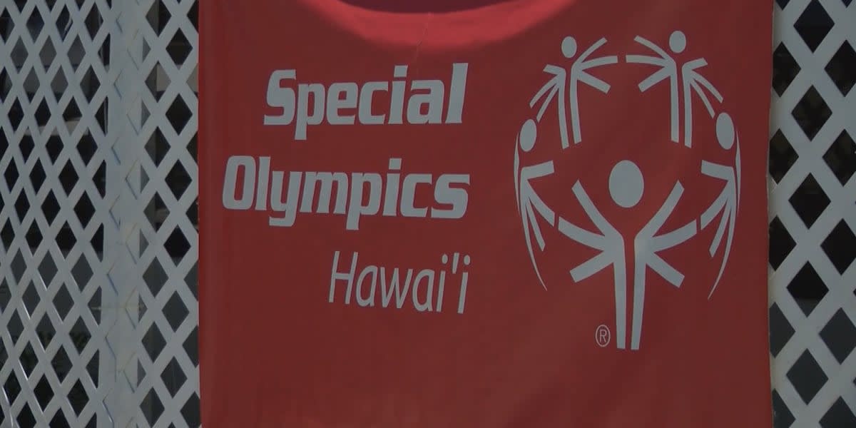 Special Olympics athletes competing on university track with volunteers cheering them on