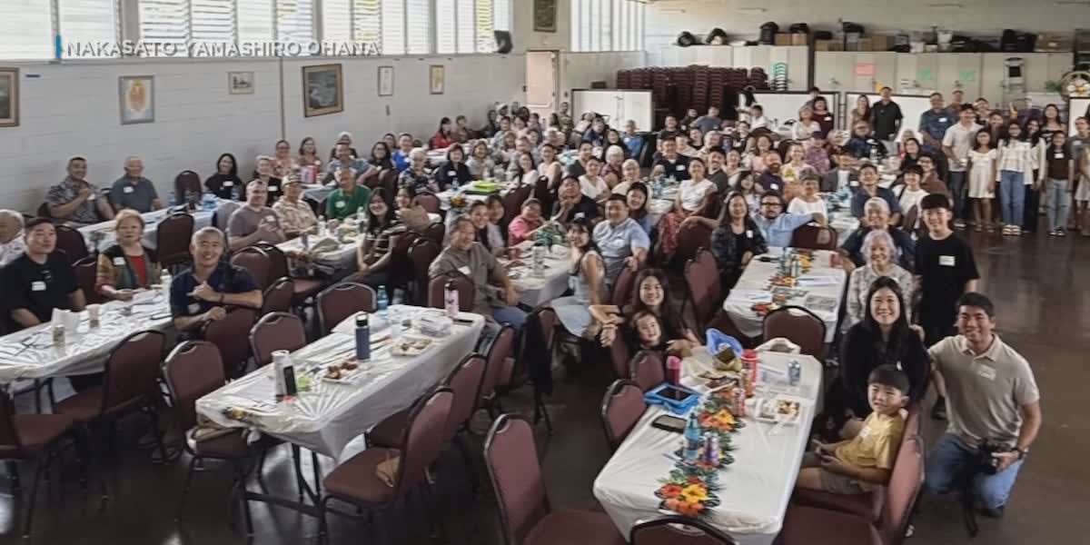 Multi-generational Hawaiian family gathered together smiling at outdoor reunion celebration
