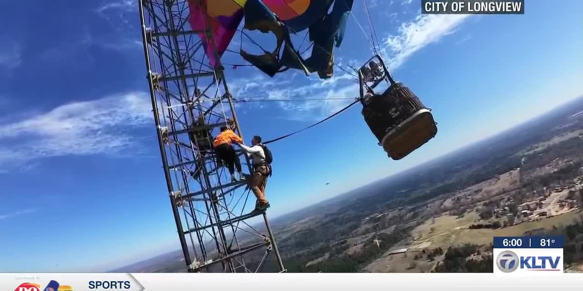 Firefighters in safety gear climbing tall radio tower during hot air balloon rescue operation