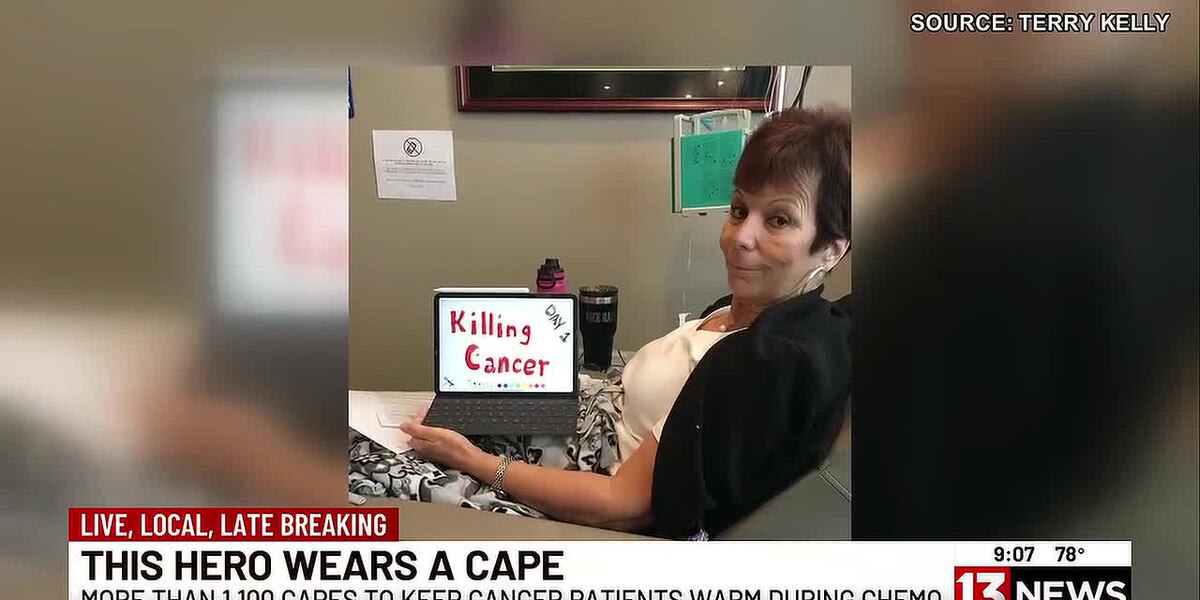 Terry Kelly holding colorful handmade comfort capes she sews for cancer patients undergoing chemotherapy treatment
