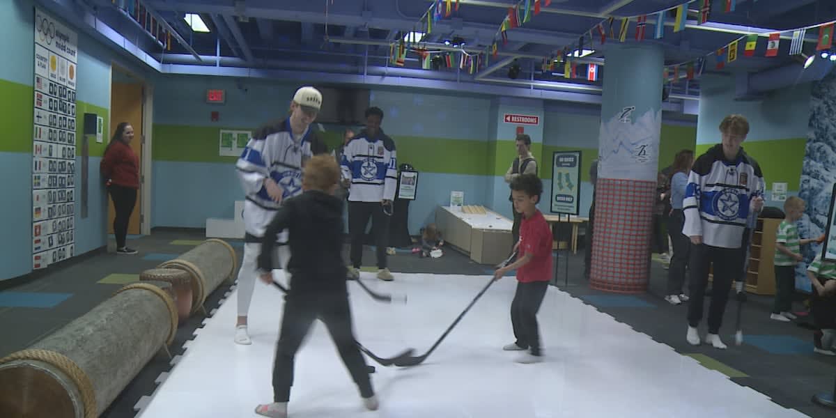 Children trying on Olympic gold medals at Lincoln Children's Museum Winter Game Village exhibit