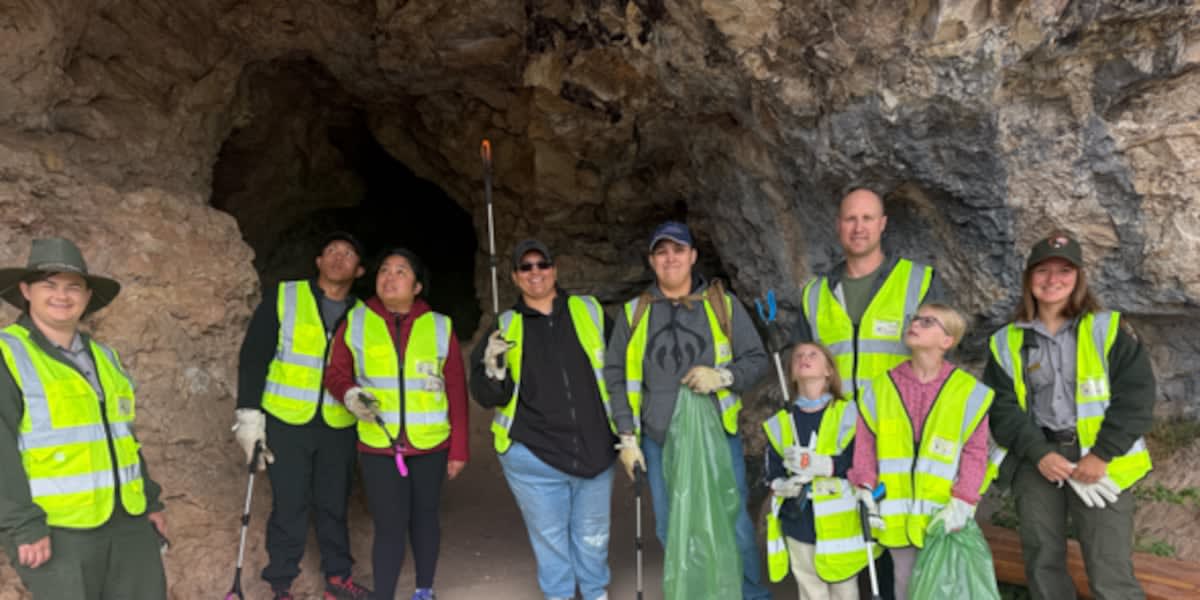 Volunteers carrying trash bags on hiking trail at Jewel Cave National Monument in South Dakota