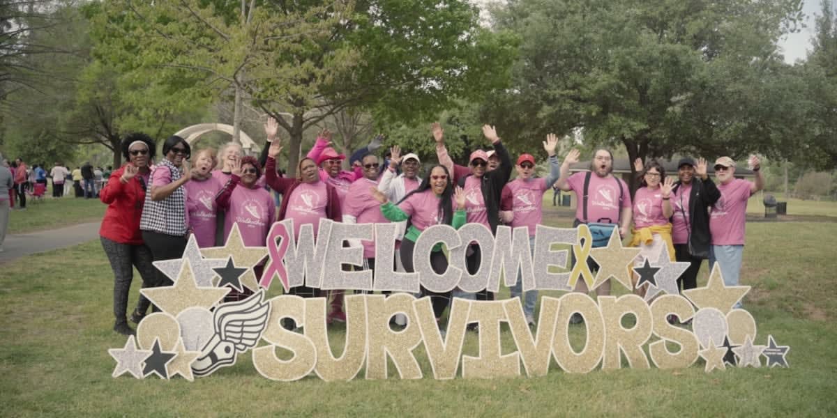 Cancer survivors and medical students walking together at community wellness event in park