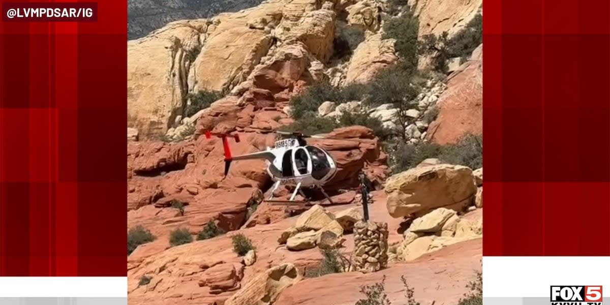 Rescue helicopter flying over red rock desert terrain near Las Vegas hiking trail