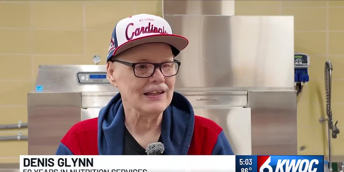 Denis Glynn smiling in Bettendorf High School kitchen where he's worked for 50 years