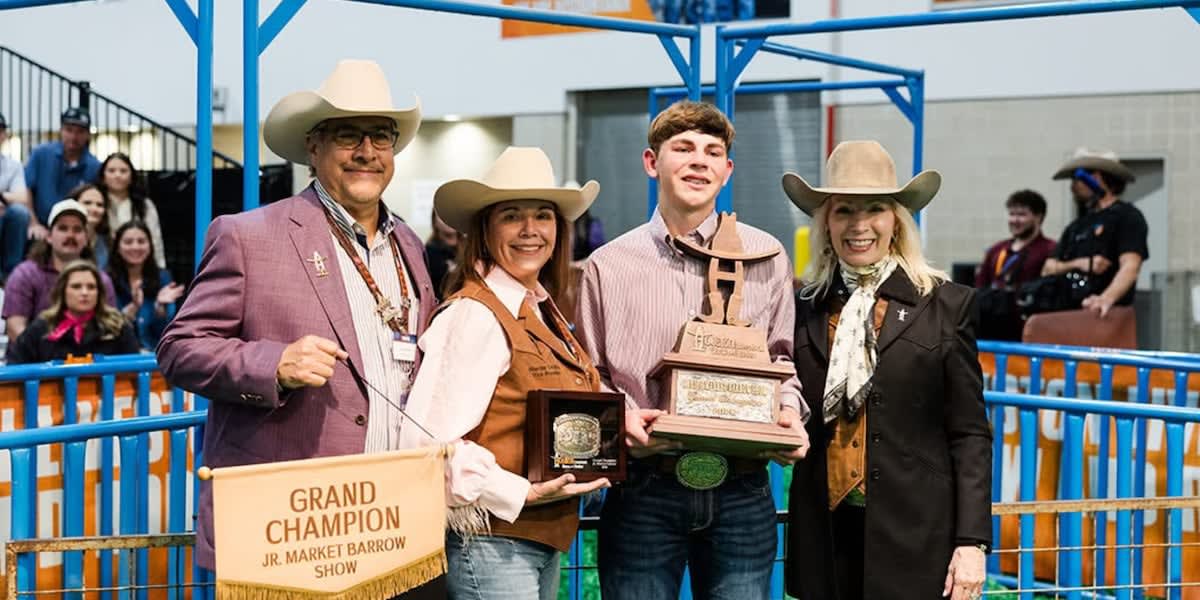 Fifteen-year-old Landry Mabry standing with his grand champion white pig Eddie at Houston Rodeo
