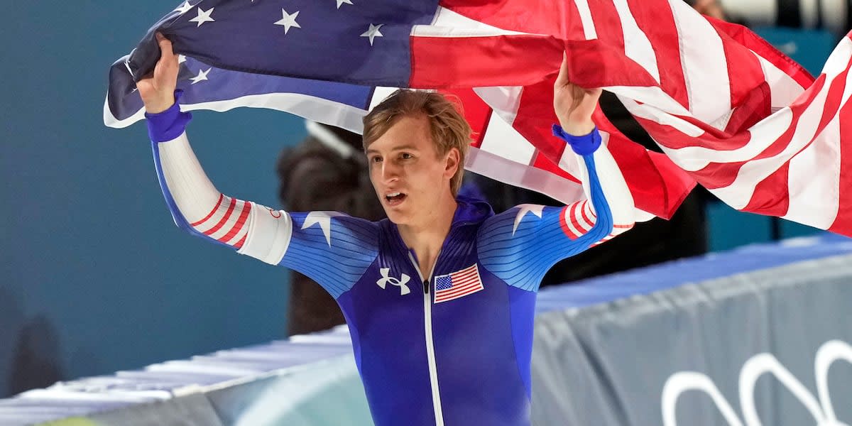Olympic speedskater Jordan Stolz celebrating gold medal win on ice rink podium