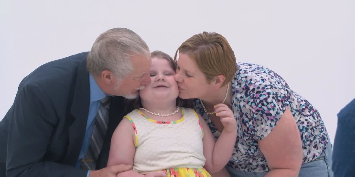 Six-year-old cancer survivor Piper smiling with family at UAB award ceremony