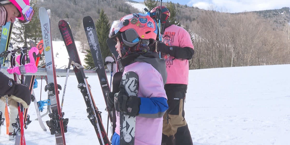 Skiers wearing pink gear gathered on snowy mountain slopes at Killington Resort breast cancer awareness event