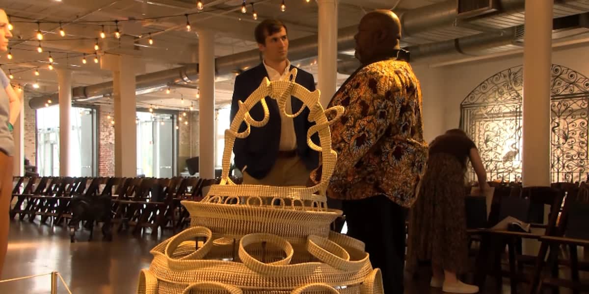 Corey Alston stands beside Big Percy, his record-breaking four-foot-tall sweetgrass basket at South Carolina State Museum
