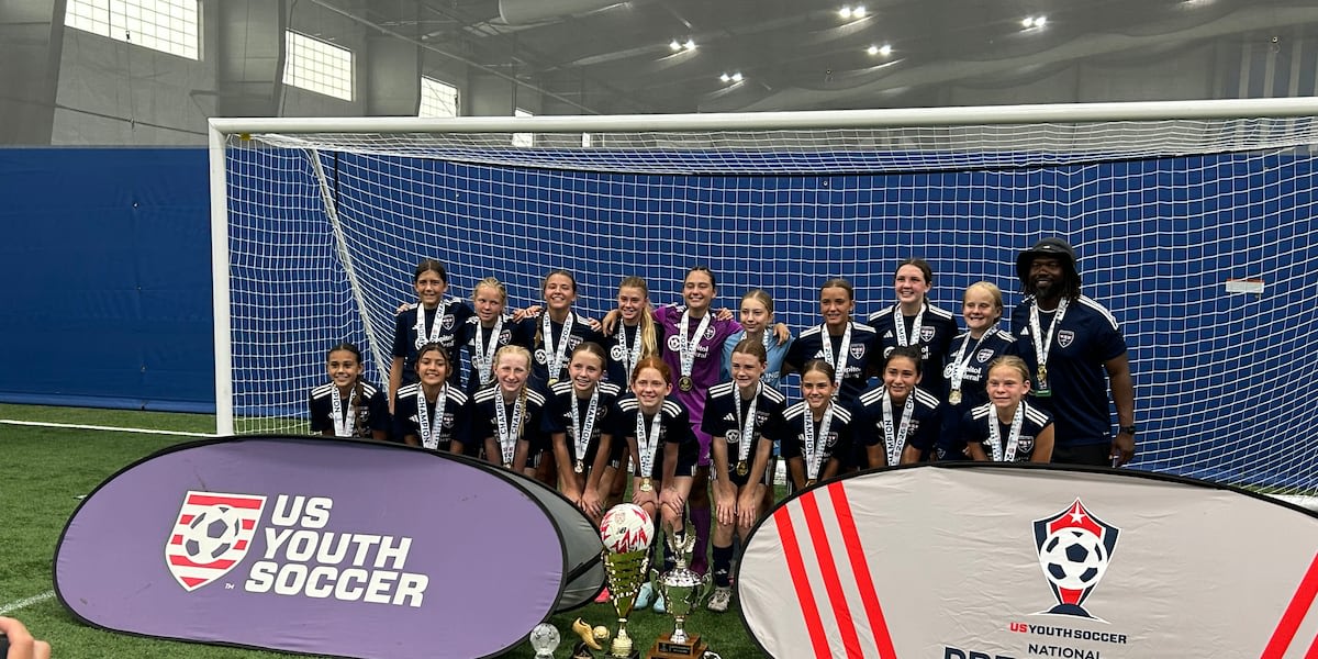 Youth soccer team celebrating with national championship trophy and individual award winners
